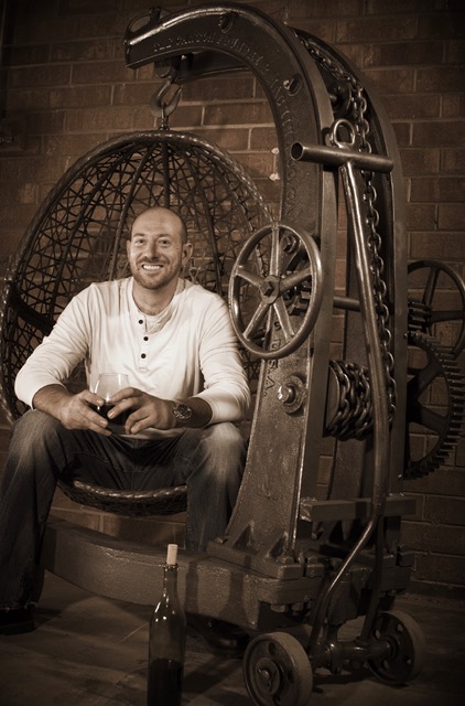 Chris-Lutzweiler-industrial-furniture-maker-sitting-in-his-rustic-hanging-egg-chair.